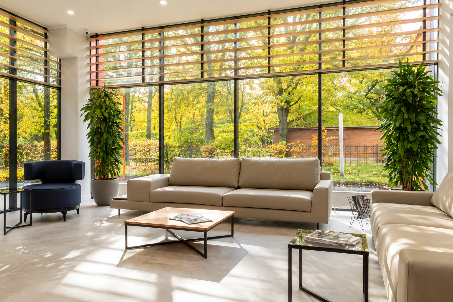 Modern sunroom with full-height glass walls, horizontal wood slats, and neutral sofas overlooking autumn trees.