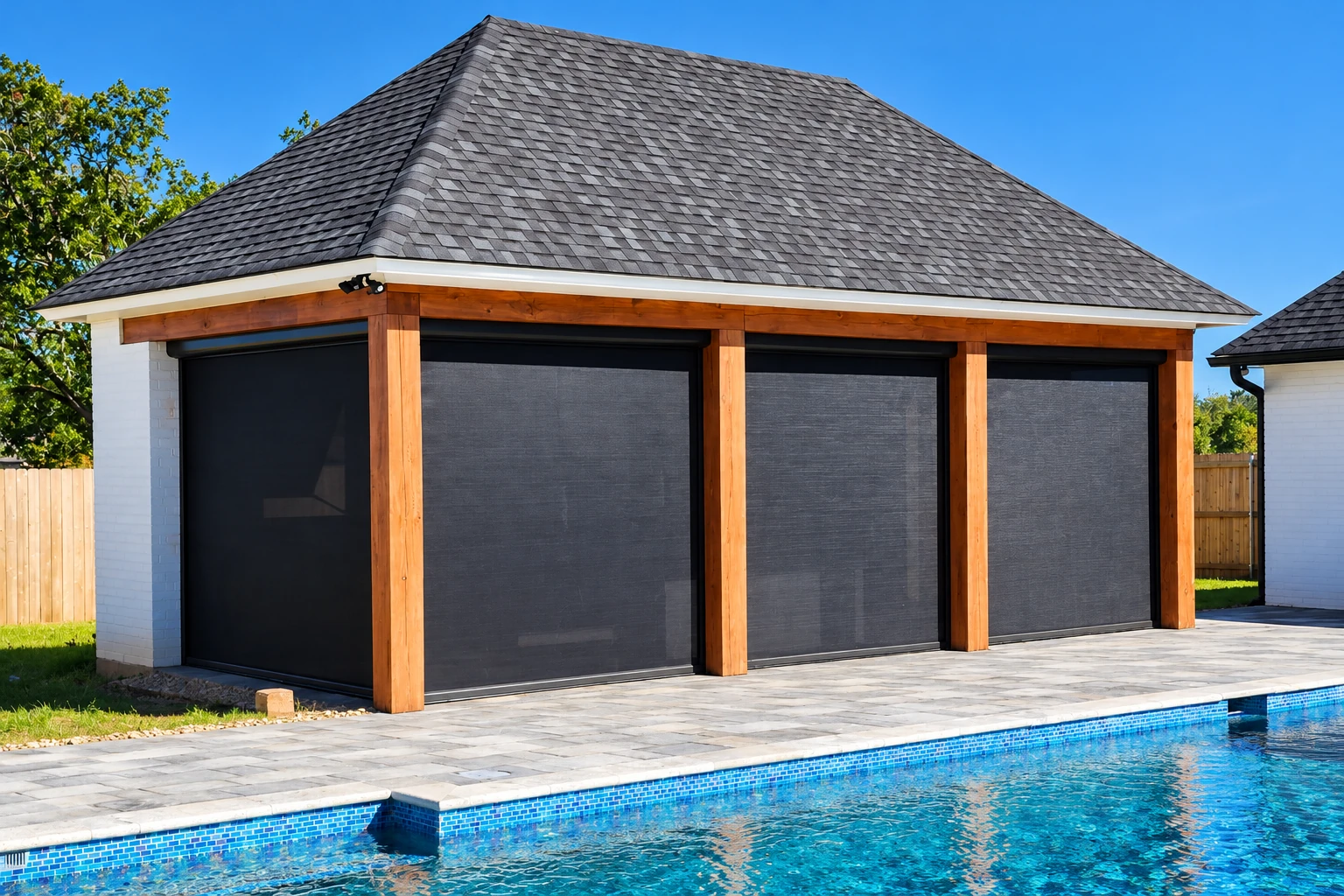 A poolside patio enclosure with dark screens, timber posts, and a large shingled roof.